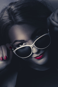 Dark fashion portrait. Female model in sunglasses