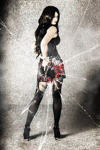 Sexy brunette woman holding gun with deadly style