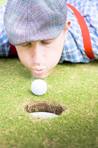 Golf Player Blowing The Ball