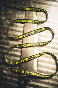 Knife with Crime Scene Ribbon on Metal Surface