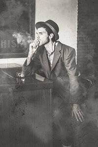 Vintage man in hat smoking cigarette in jazz club