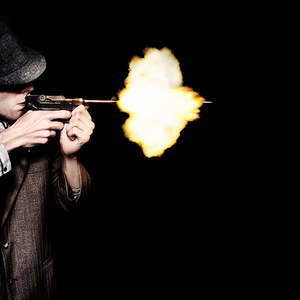 Vintage Gangster Man Shooting Gun On Black