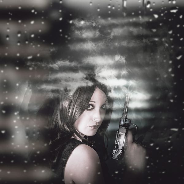 Pretty female spy hiding in shadows with weapon Print