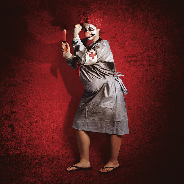 Scary clown doctor about to give jab with syringe Print