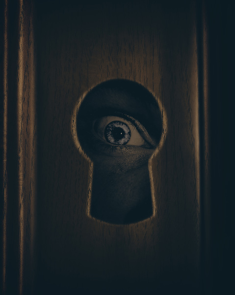 Eye looking through door keyhole Print