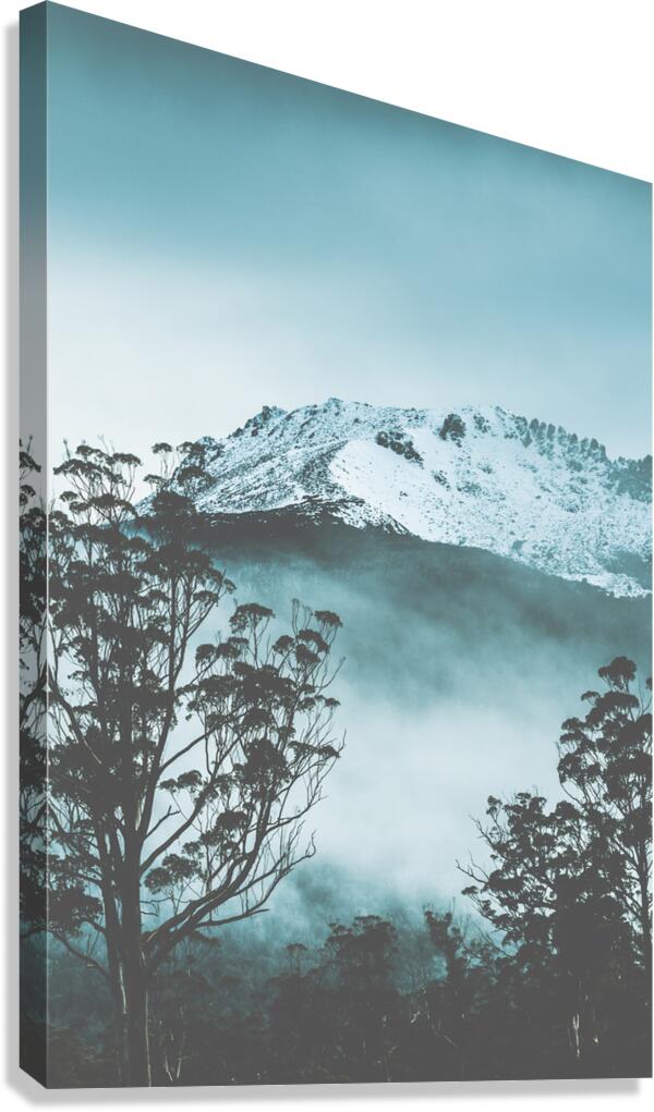 Dramatic dark blue mountain with snow and fog Canvas Print