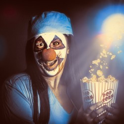 Scary clown watching horror movie in THEATER