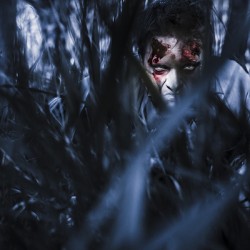 Evil man hiding in silence at dark forest 