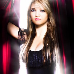 Female performer behind the stage curtain light