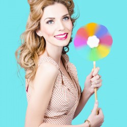 Blonde girl holding windmill fan. Natural energy