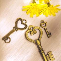 Three heart shaped keys with flowers on wooden table