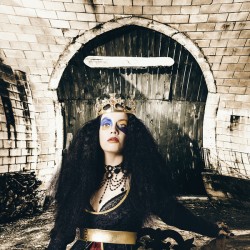 Fashion beauty princess sitting by castle door