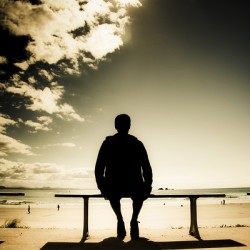 Young Man In Silhouette Sitting In The Sun