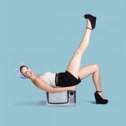Pinup girl balancing on television set