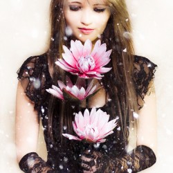 Beautiful young woman holding a delicate flower