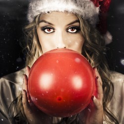 Young Christmas Girl Blowing Up Party Balloon